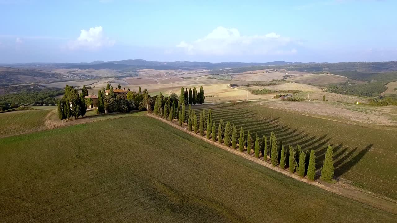 villa italiana con camino bordeado de cipreses en la campiña toscana cerca de florencia, toma aérea de dolly-out