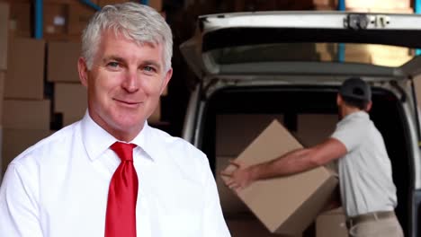 Animation-of-the-words-Free-Delivery-over-happy-man-with-clipboard,-delivering-goods