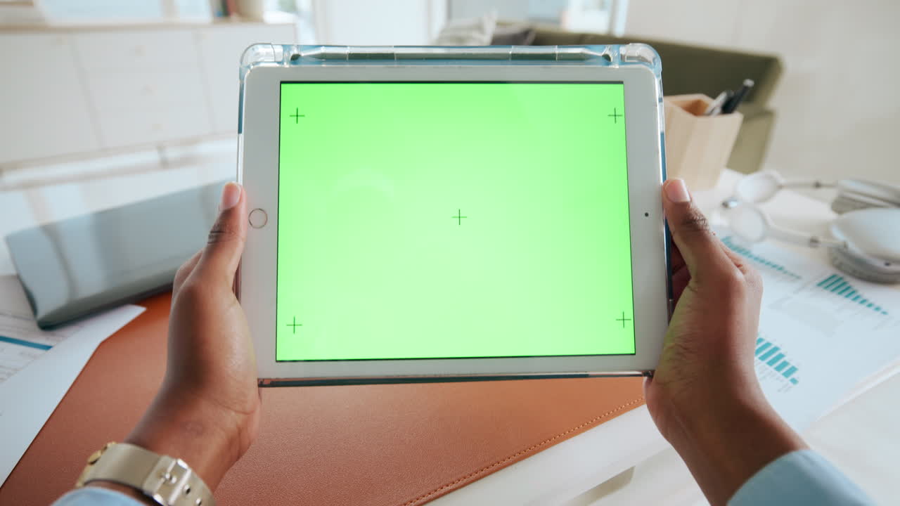 초록색 화면 을 가진 태블릿 을 들고 있는 손