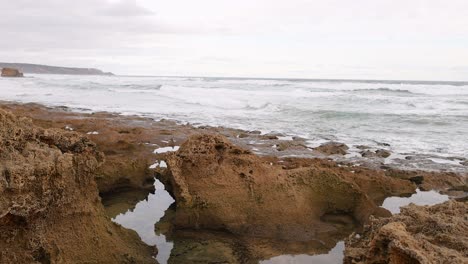 ocean waves hitting rock pools on a winter day