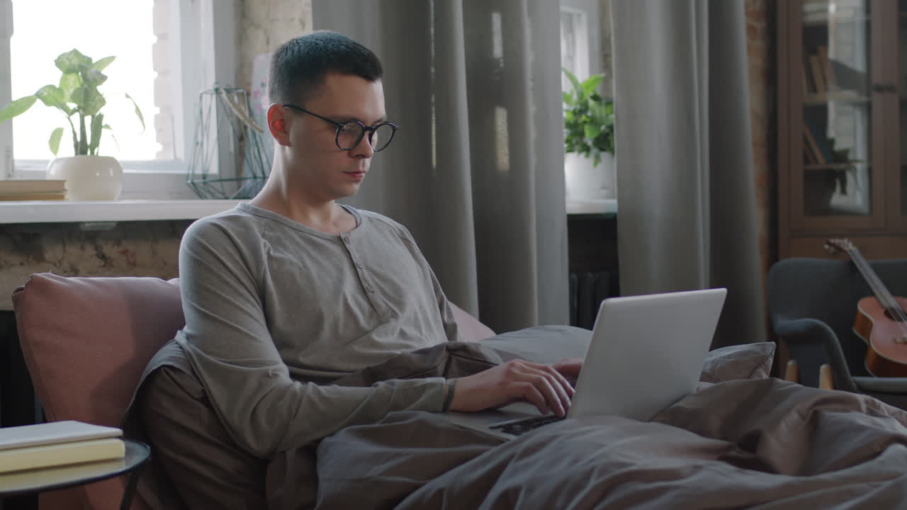 Freelancer Working On Laptop From Bed