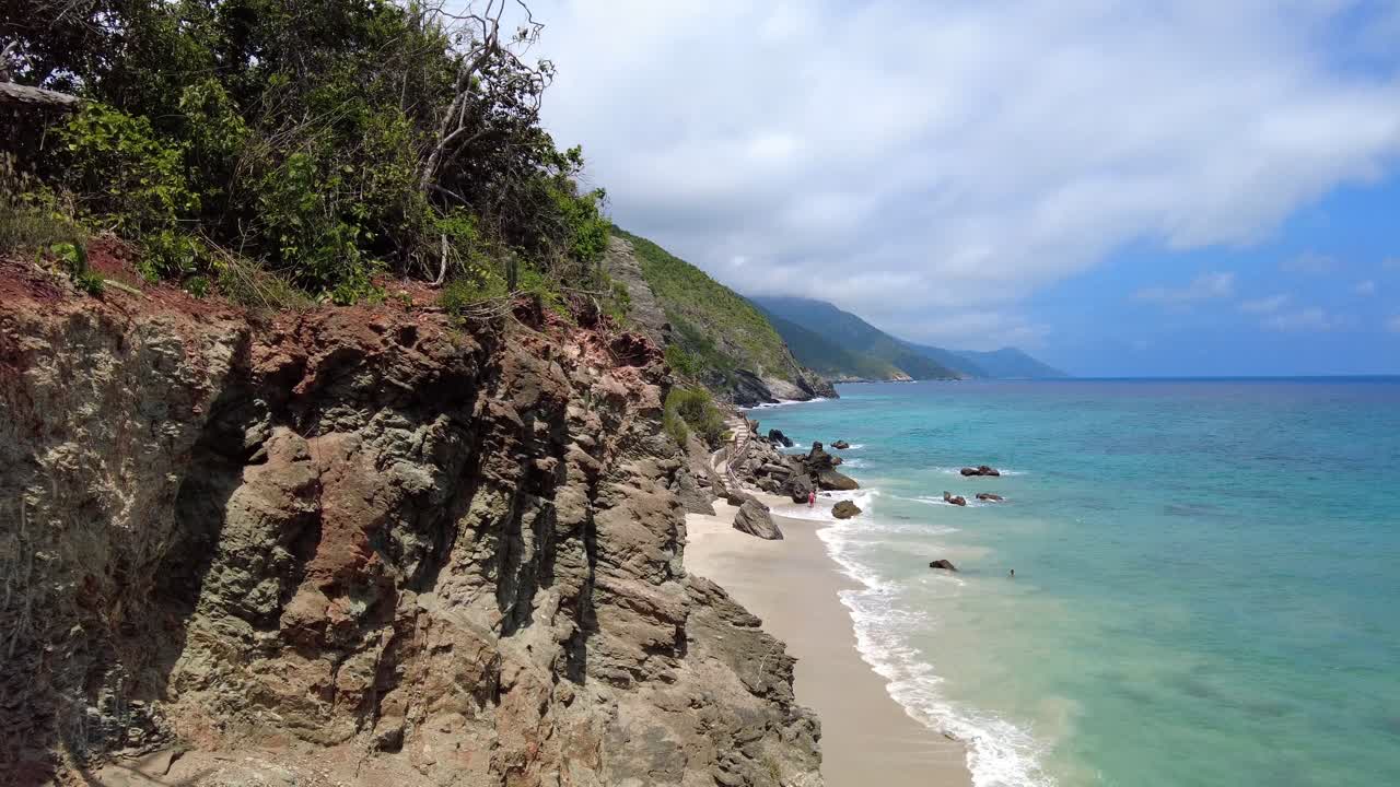 Inquadratura di ambientazione della spiaggia di Tinikijima, una spiaggia appartata in una giornata di sole con sabbia bianca sulle coste del Mar Caraibico, Stato di Aragua, Venezuela.