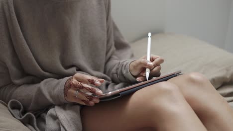 woman drawing on tablet in bed