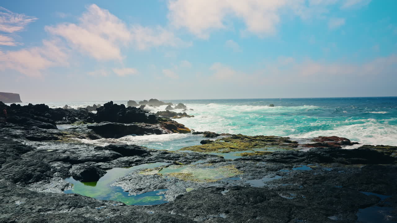 화산의 바위 해안선에 부 ⁇ 히는 거친 바다 파도의 느린 촬영