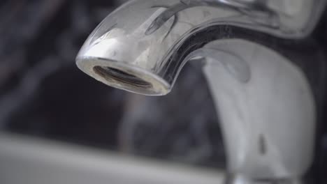 water dripping from chrome-plated tap, loop background