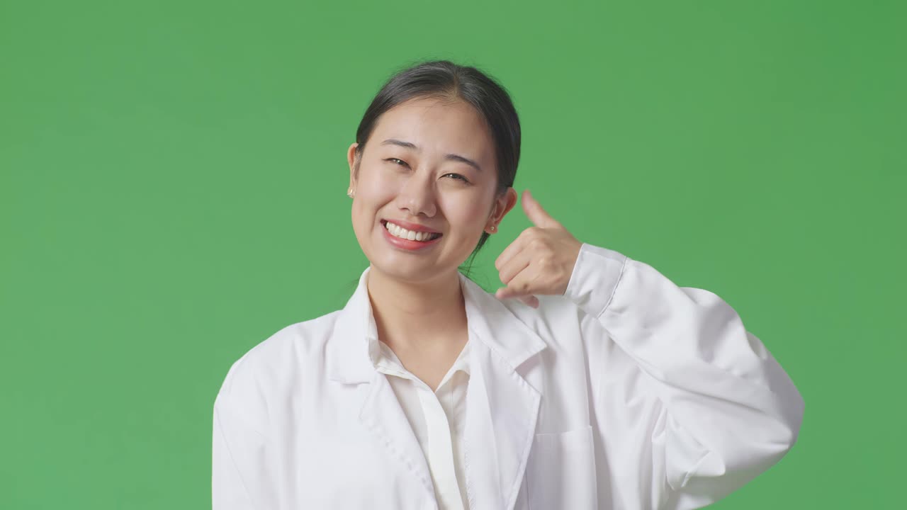 실험실 코트를 입은 여성이 전화 제스처를 하고 있습니다.