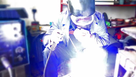 technician worker working wearing industrial uniforms and welded iron mask at steel welding plants with sparks flying, industrial safety first concept.