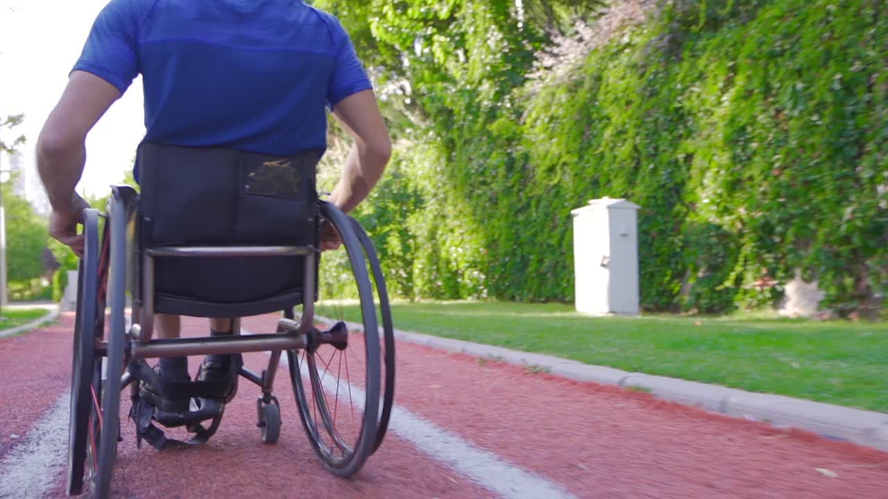 Young disabled person driving a wheelchair in slow motion.