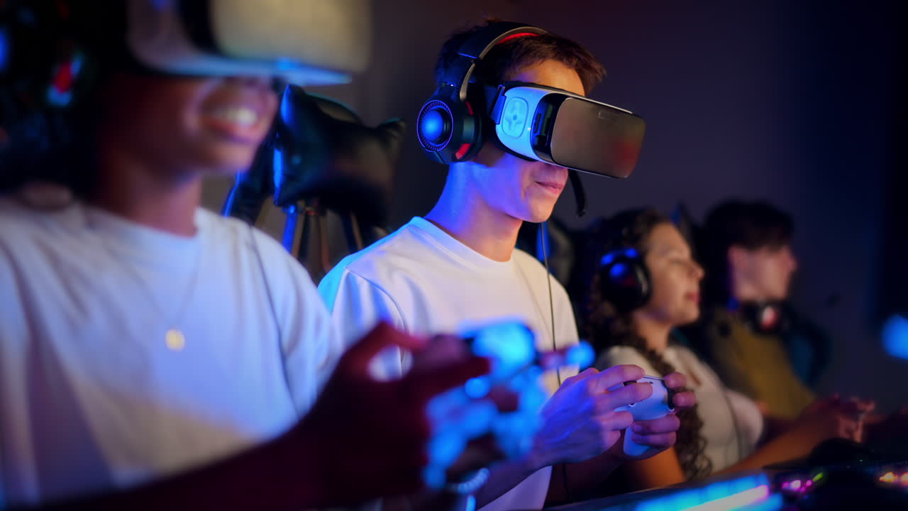 Teen smiling boy in VR headset playing video games in video game club with blue illumination using a gamepad