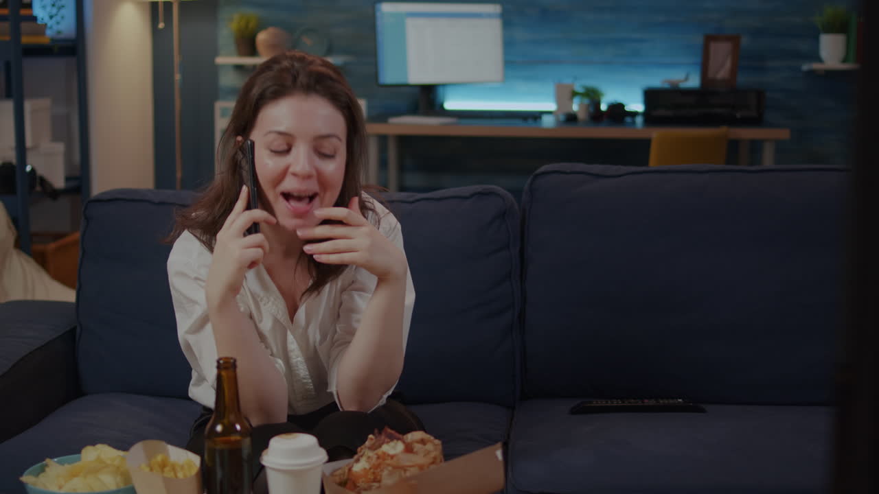 Caucasian adult enjoying phone call with friend in living room