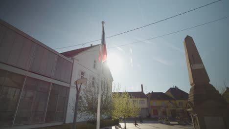 Arcing-shot-of-a-french-flag-beside-a-monument