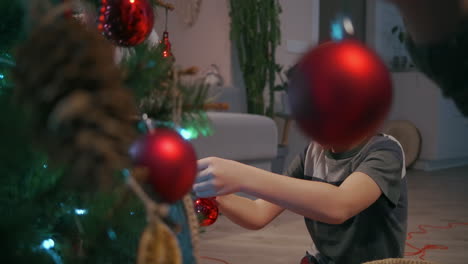 niño usa juguetes de navidad para el árbol de navidad. imágenes de alta calidad en 4k