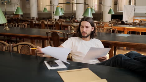 Young-student-working-on-study-project-in-library