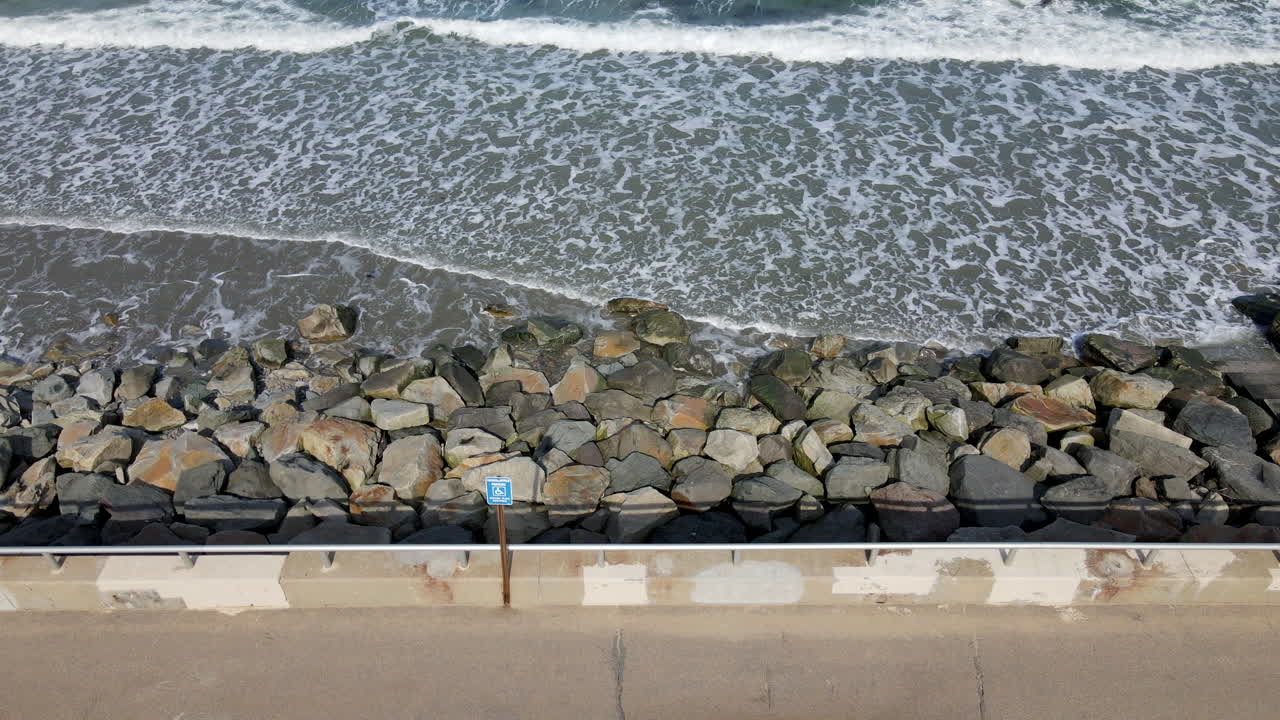 Gentle lapping waves breaking against large rocks and boulders Premium ...