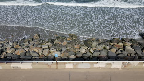 gentle lapping waves breaking against large rocks and boulders