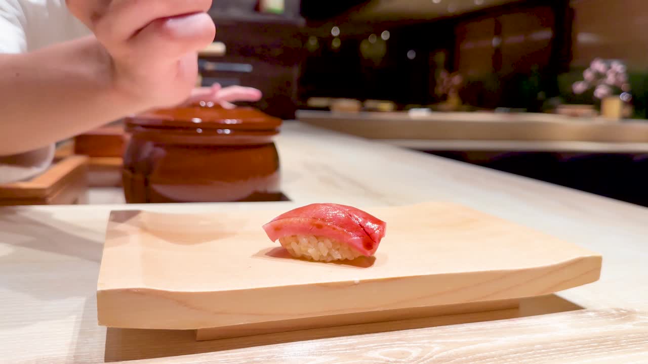 el chef coloca hábilmente el sushi en una tabla de madera.