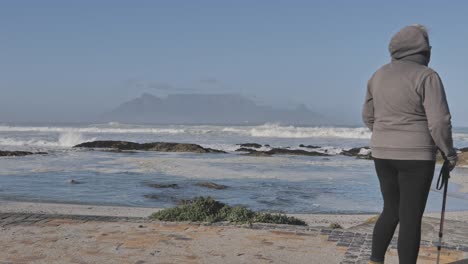 table mountain view from blouberg beach with waves crashing on rocks on a clear day