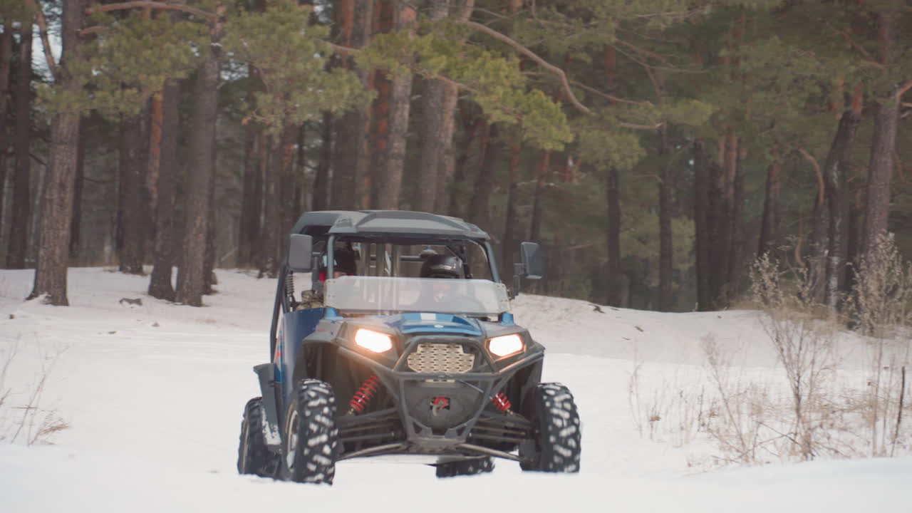 Karlı çam sürüşü. Farları açık, karla kaplı çam ormanında macera dolu bir ATV yolculuğu. Kışın karlı çam ormanlarında, dağınık çalılıklar arasından heyecan verici bir ekstrem spor sürüş deneyimi.