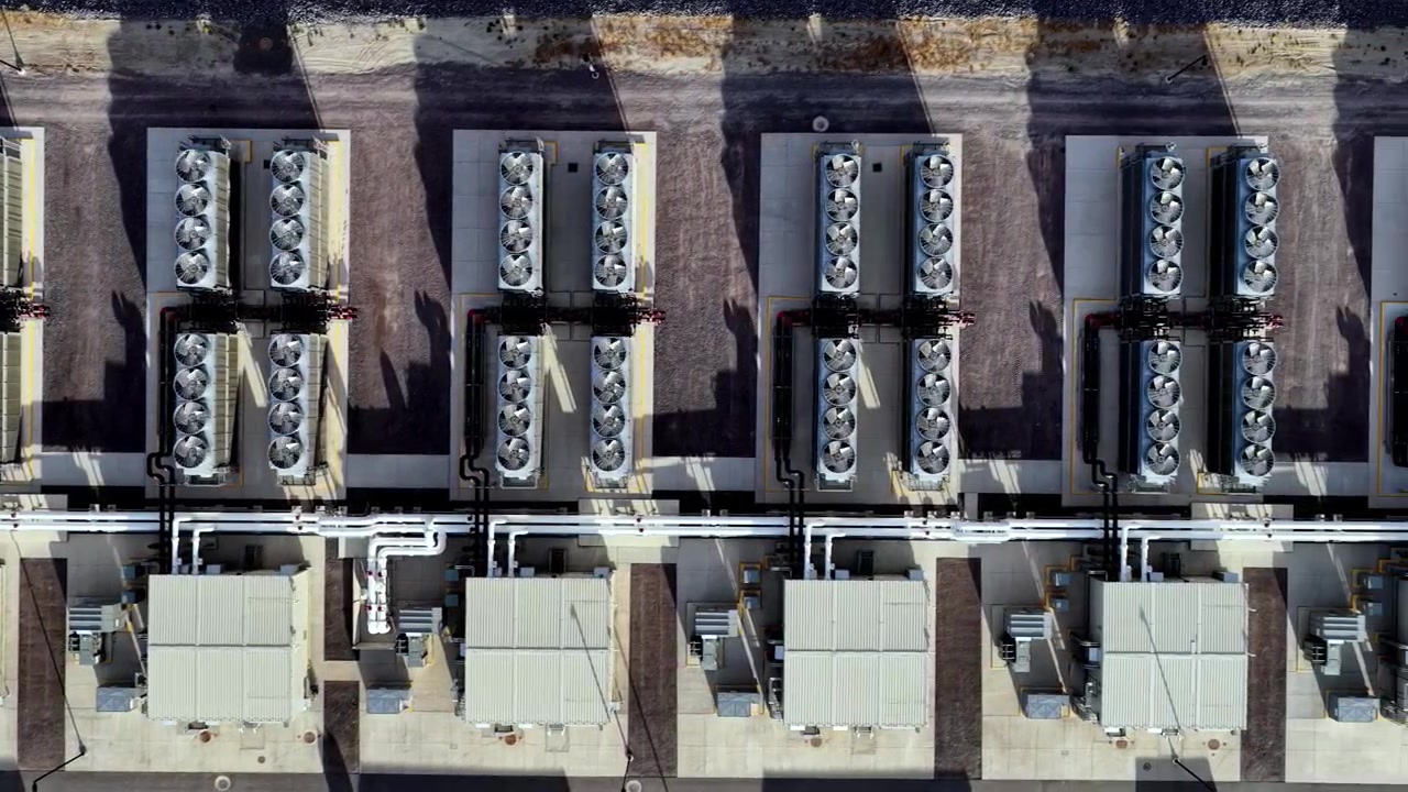 Video drone verticale che rivela ventole di ventilazione simmetriche e sistemi di raffreddamento in una struttura di data center iperscalabile, con effetto di rivelazione a scorrimento.