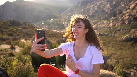 cheerful woman recording video and showing surroundings in highlands