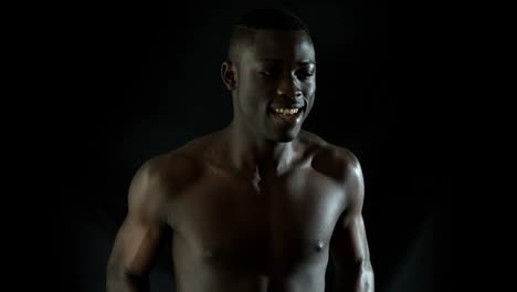 shirtless man jogging against black background