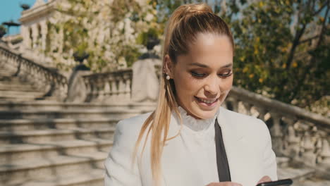 stylish young woman checking her smartphone outdoors.