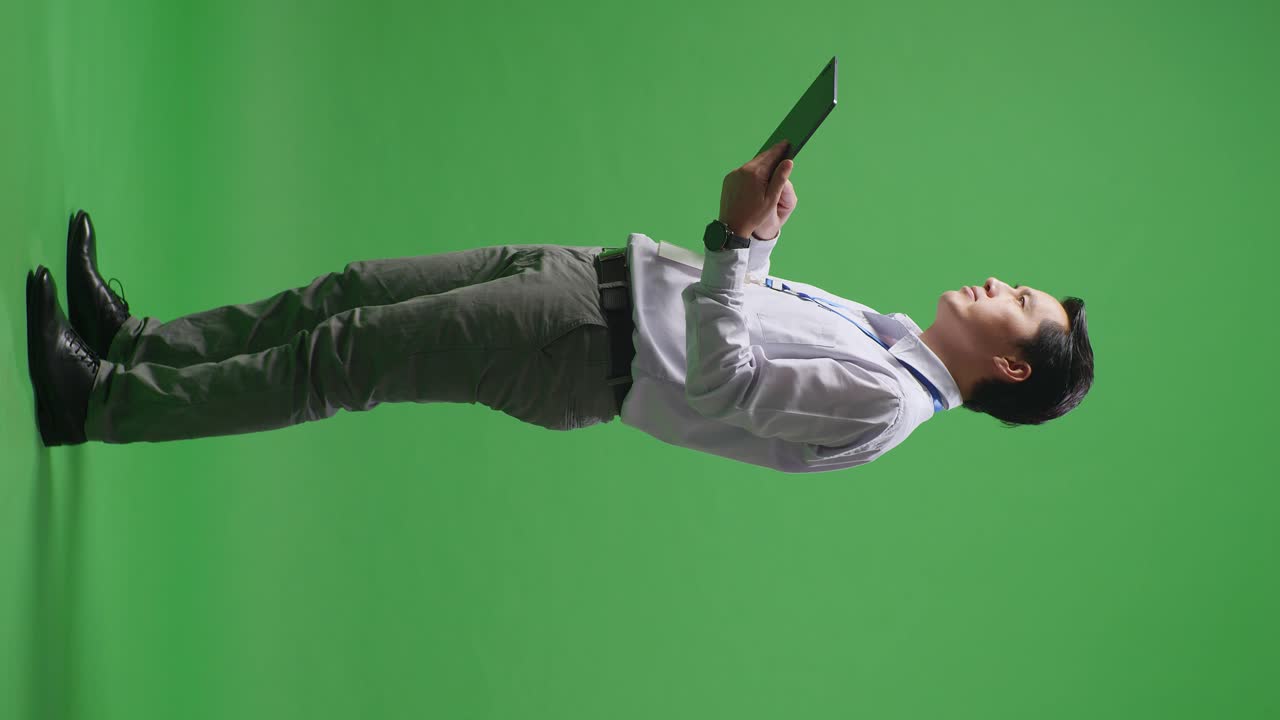 비즈니스맨이 녹색 스크린에서 태블릿을 들고 있다