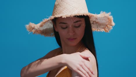 young asian woman putting sunscreen on shoulder enjoys the sun