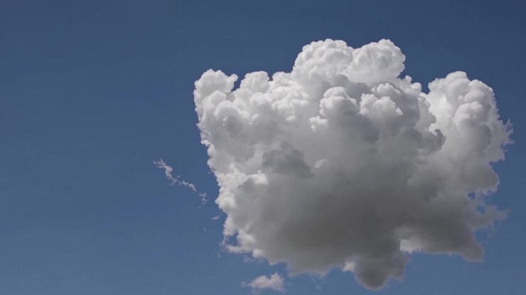 Single White Cumulus Cloud Drifting Across Clear Blue Sky