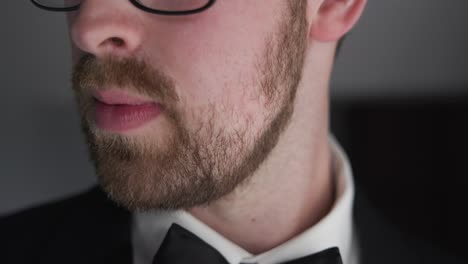 Close-up-shot-of-groom-looking-towards-the-camera-while-in-his-outfit-with-his-beard