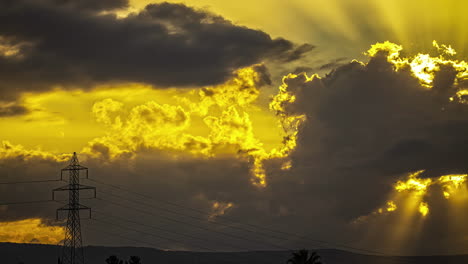 lapso de tiempo de dramáticas nubes de puesta de sol que se mueven sobre cables eléctricos y montañas