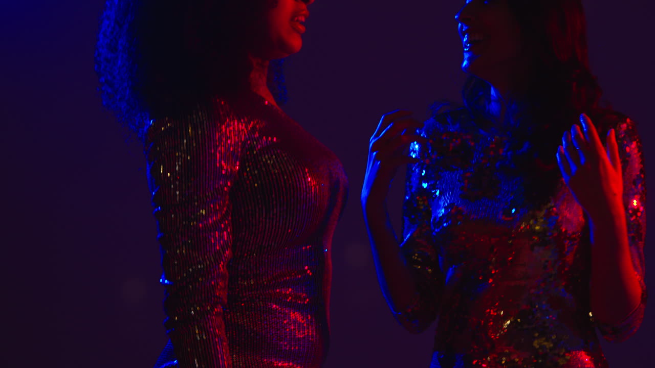 Close Up Of Two Women In Nightclub Bar Or Disco Dancing Talking And Having Fun Together