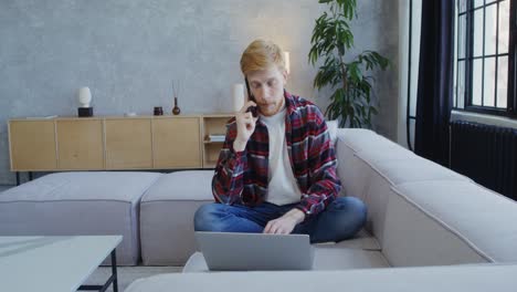 hombre trabajando desde casa y hablando por teléfono