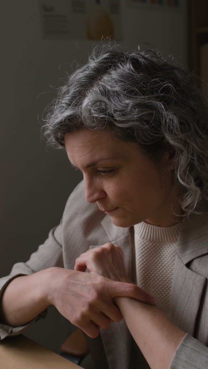 Woman Examining Her Wrist in a Consultation