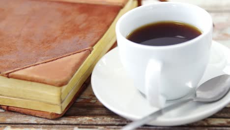 coffee cup and book on wooden plank