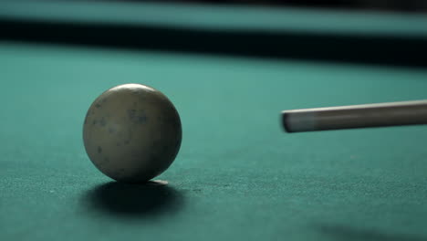 Close-Up-Pool-Cue-hitting-Cue-Ball-on-Green-Billiard-Table