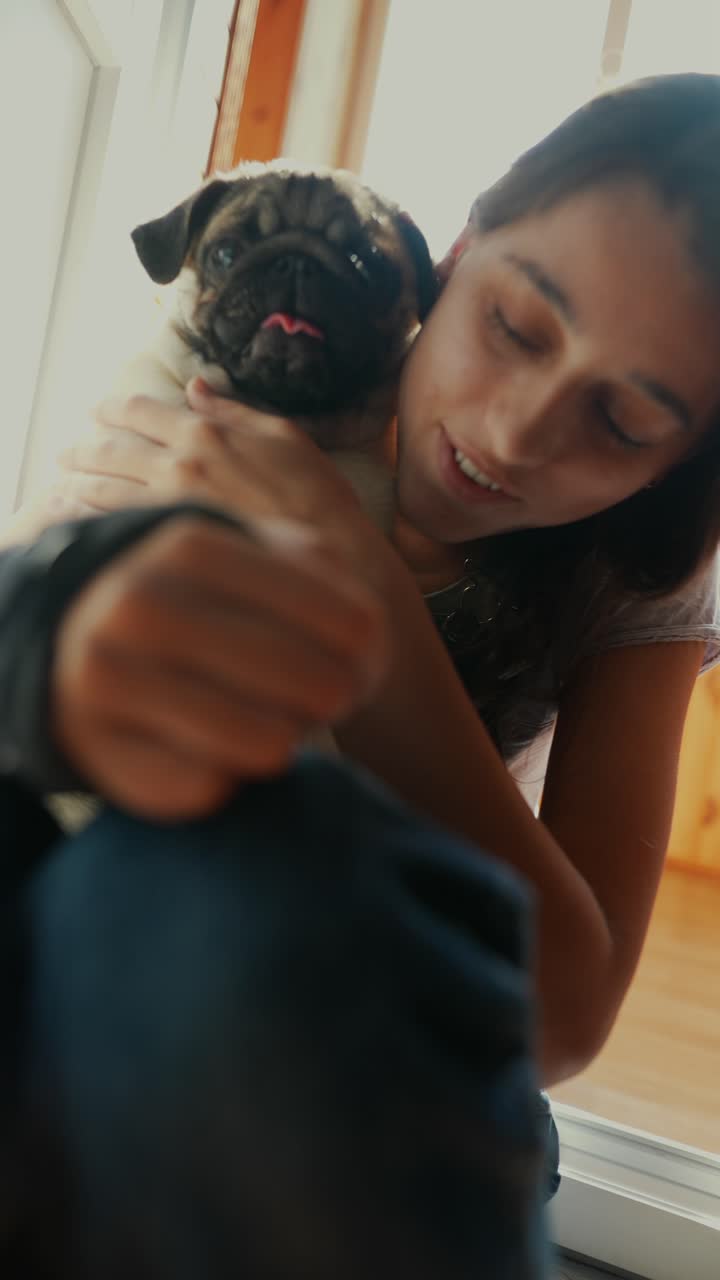 una chica acurrucando a un cachorro.