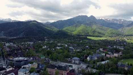 sobrevuelo de zakopane, polonia, un pueblo turístico con arquitectura goral tradicional cerca de las montañas polacas tatra, tierras de cultivo, bosques, pico giewont y gran salto de esquí krokiew - 4k rastreando hacia atrás