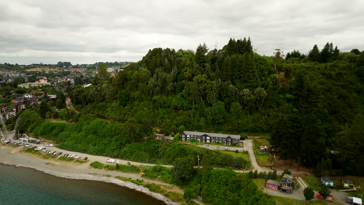 Lush hillside and calm lakeside shore, aerial dolly view, Puerto Varas