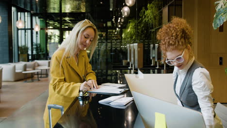 blonde woman and receptionist in a hotel