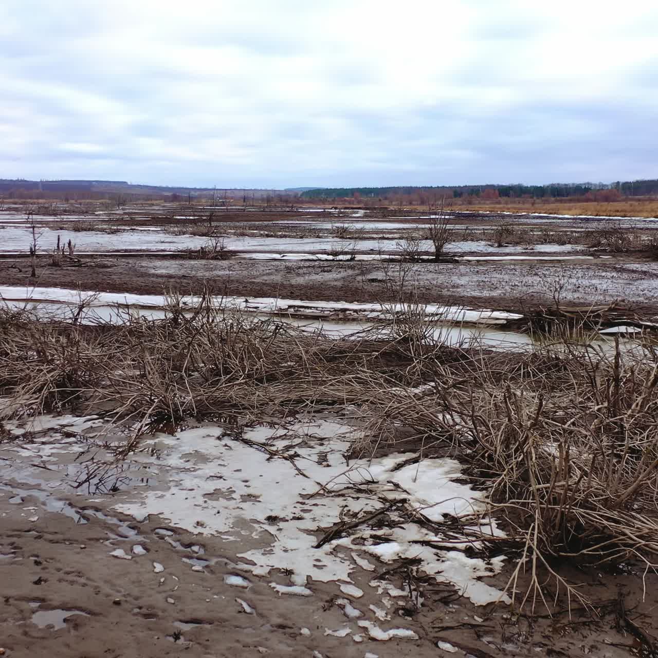 Dead earth destroyed by human development. Global warming. Dried lake with a narrow stream of dirty water. Climate change, ecology. Water problems