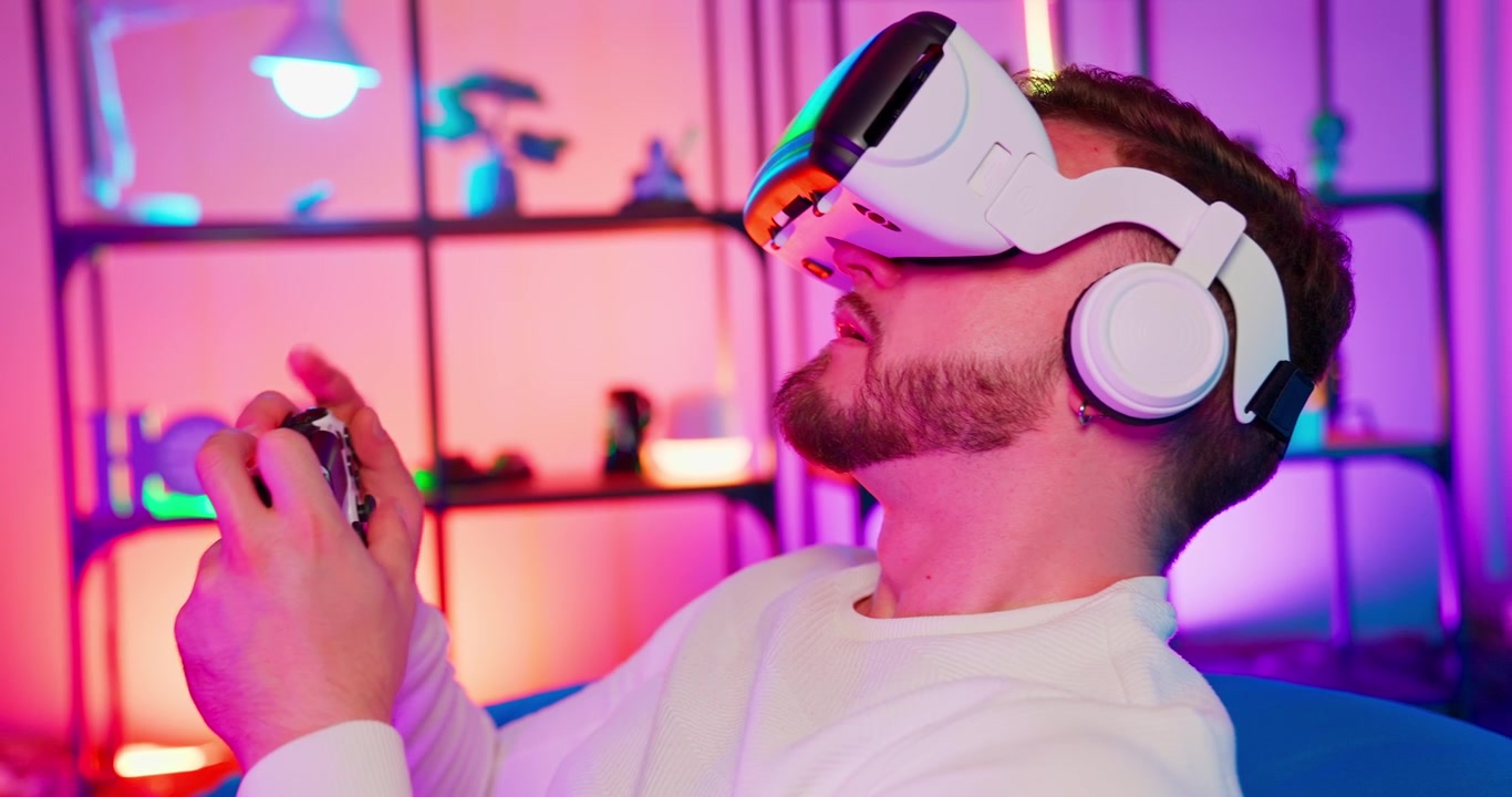 Giovane uomo che gioca a un gioco di realtà virtuale con un controller in una stanza al neon.