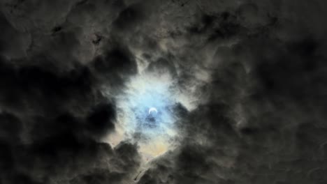 wide handheld shot of a almost total solar eclipse behind a dark and overcast sky on a summer day in utah of 2023