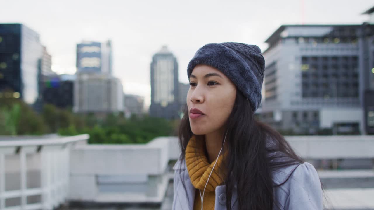 mujer asiática caminando usando un teléfono inteligente y comiendo un sándwich