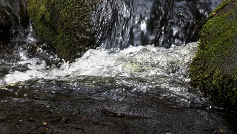 Close-up-low-angle-view-of-water-from-Burbage-Brook-flowing-over-rocks-in-Padley-Gorge-in-Peak-District-National-Park,-United-Kingdom