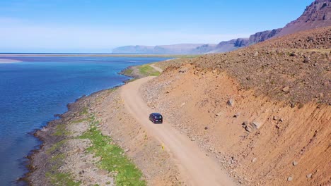 Antena-Sobre-Una-Furgoneta-Negra-Que-Viajaba-Por-Un-Camino-De-Tierra-En-Islandia-Cerca-De-La-Playa-De-Raudisandur-En-Los-Fiordos-Del-Noroeste-2