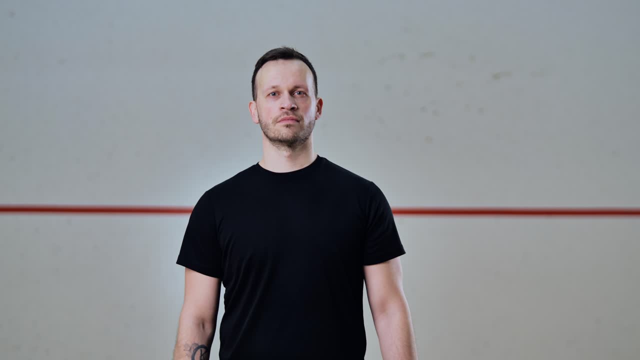 Blurry to sharp reveal of man walking into center frame inside empty court