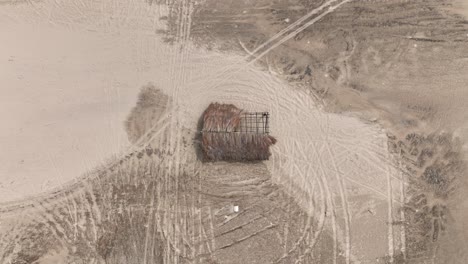 overhead view of thatched hut with broken roof by the river in parnaiba, brazil. - aerial ascend shot