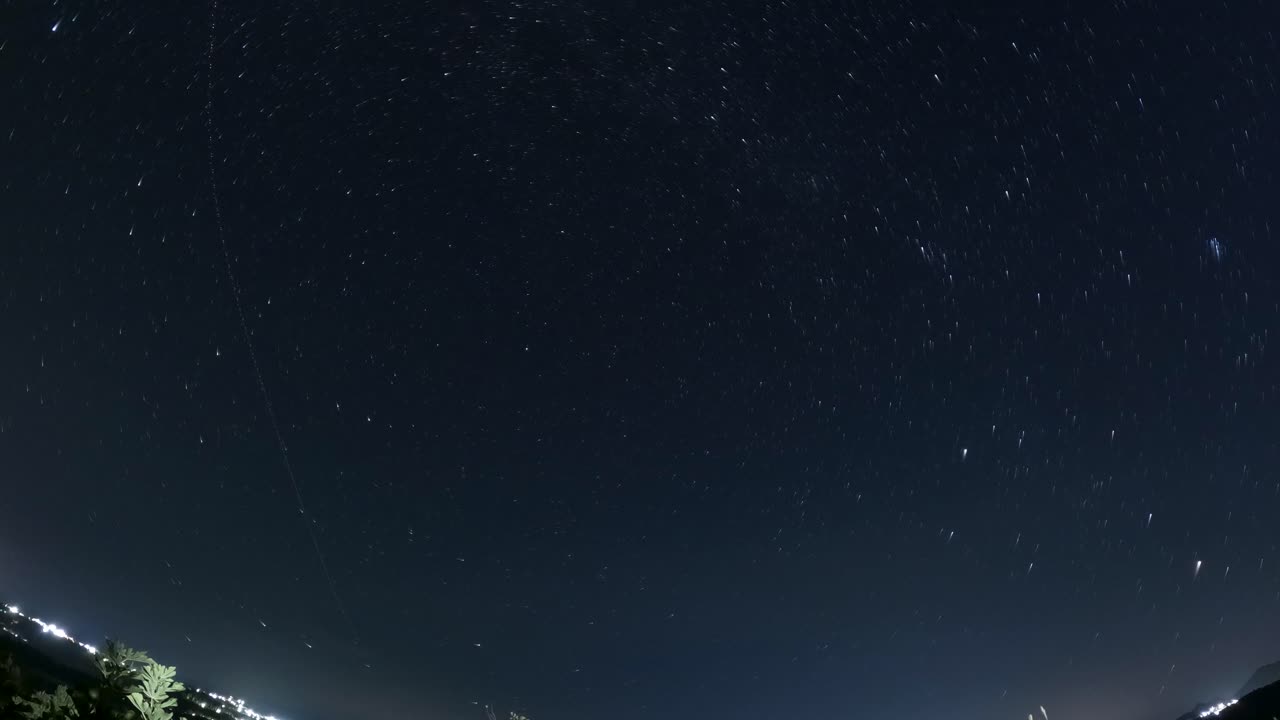 4K Star Trails Night Sky Time Lapse Over City Lights with Rotation Effect and Deep Blue Atmosphere
