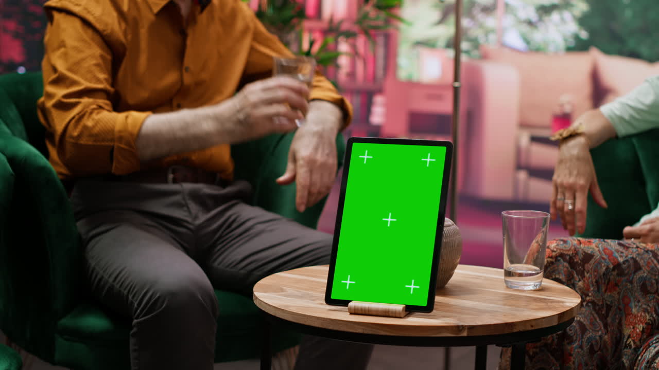 dos personas mayores divirtiéndose y charlando junto a una pantalla clave de croma aislada